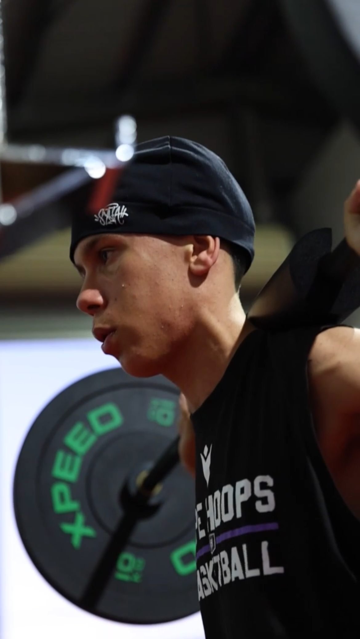 Athlete in a HIPE Hoops singlet preparing for a barbell squat